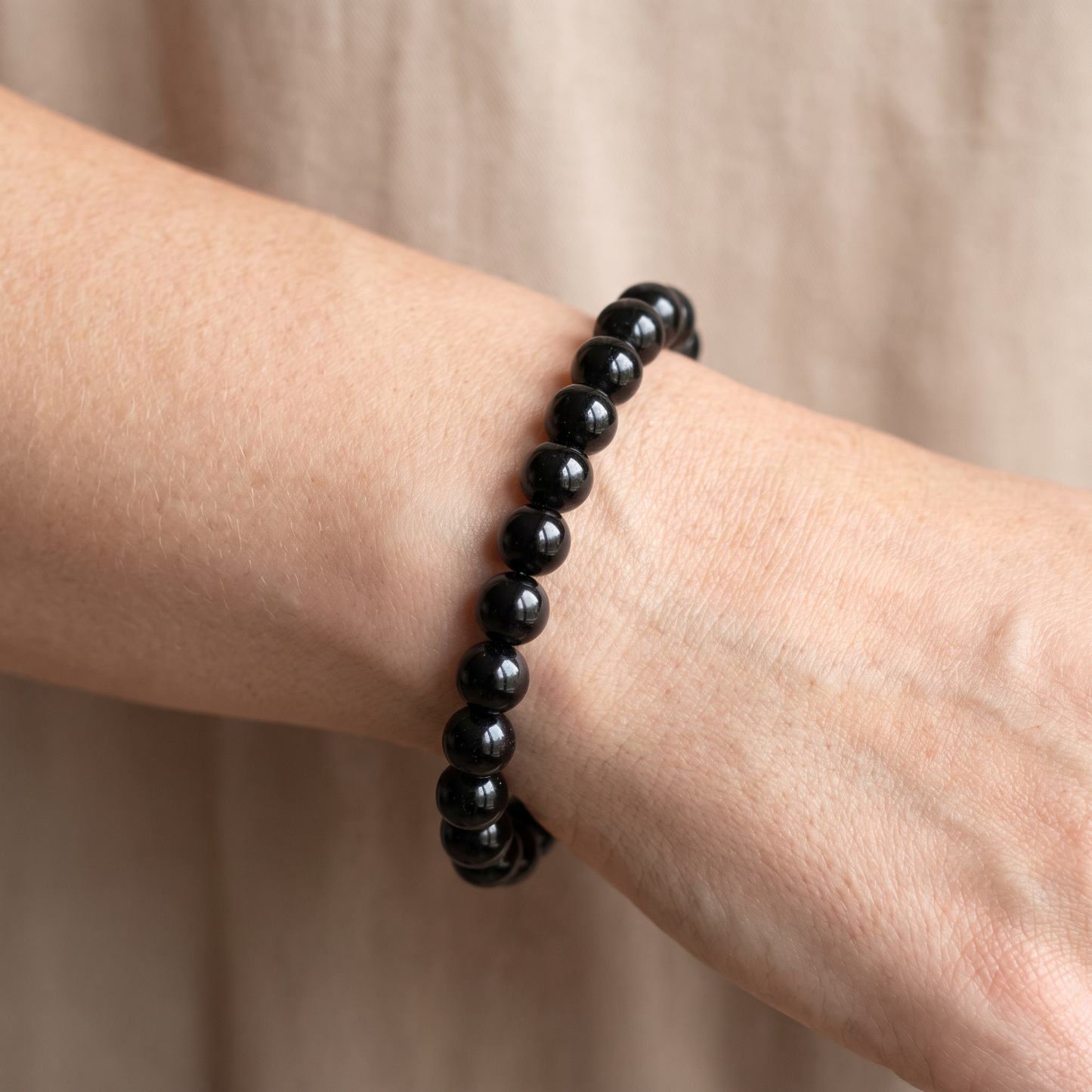 Black Tourmaline 8mm bead size reference shown on wrist - Manushaa Gems