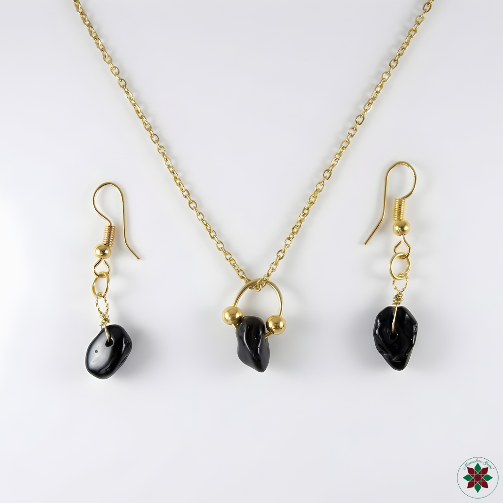 Black tourmaline necklace and drop earrings flat lay on ivory — grounding crystal jewellery set by Manushaa Gems