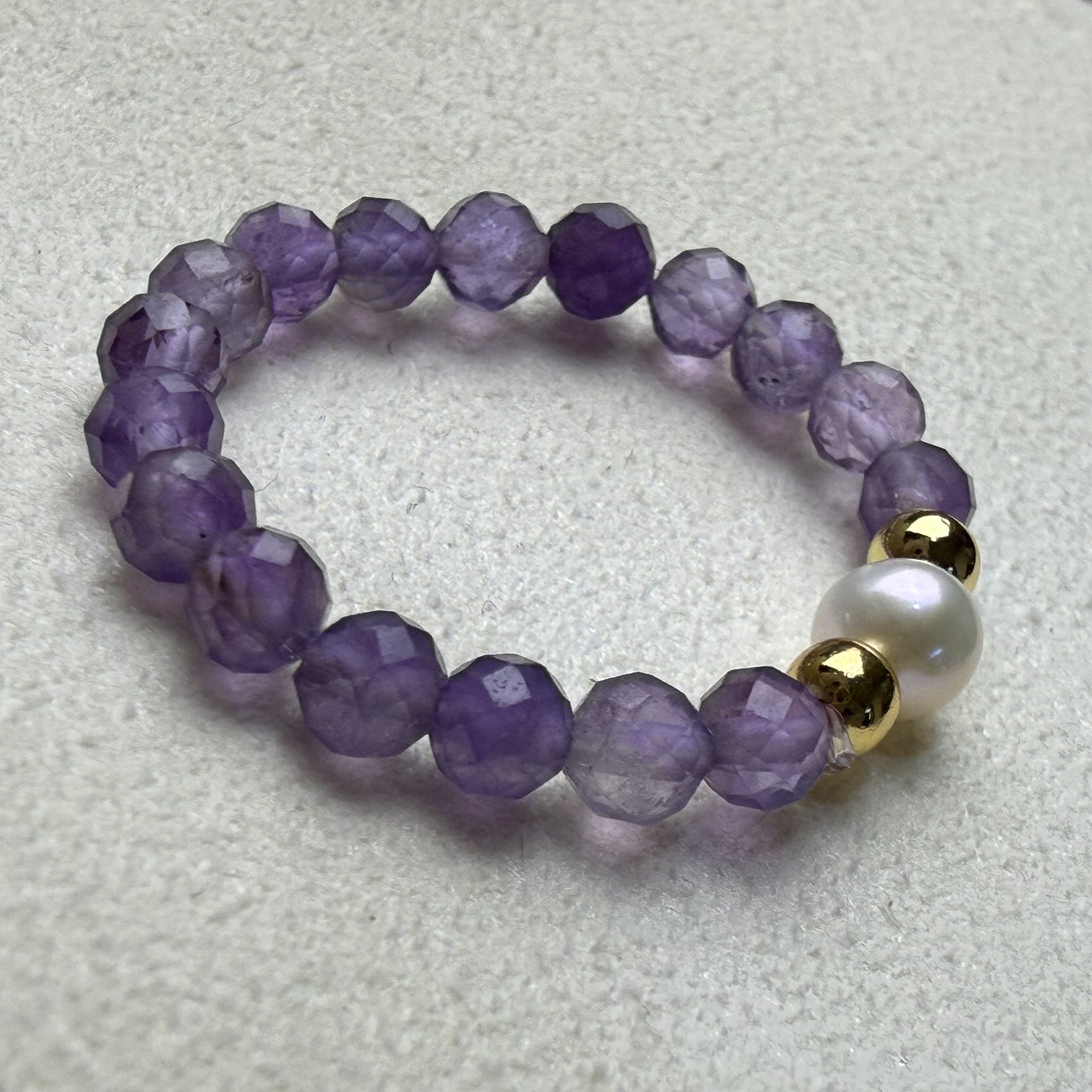 Close-up of violet 3mm faceted amethyst beads with freshwater pearl and gold accents – Manushaa Gems