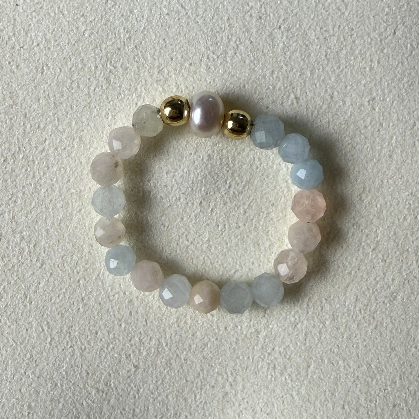 Close-up of pastel pink, peach and lilac faceted morganite beads with freshwater pearl and gold accents – Manushaa Gems