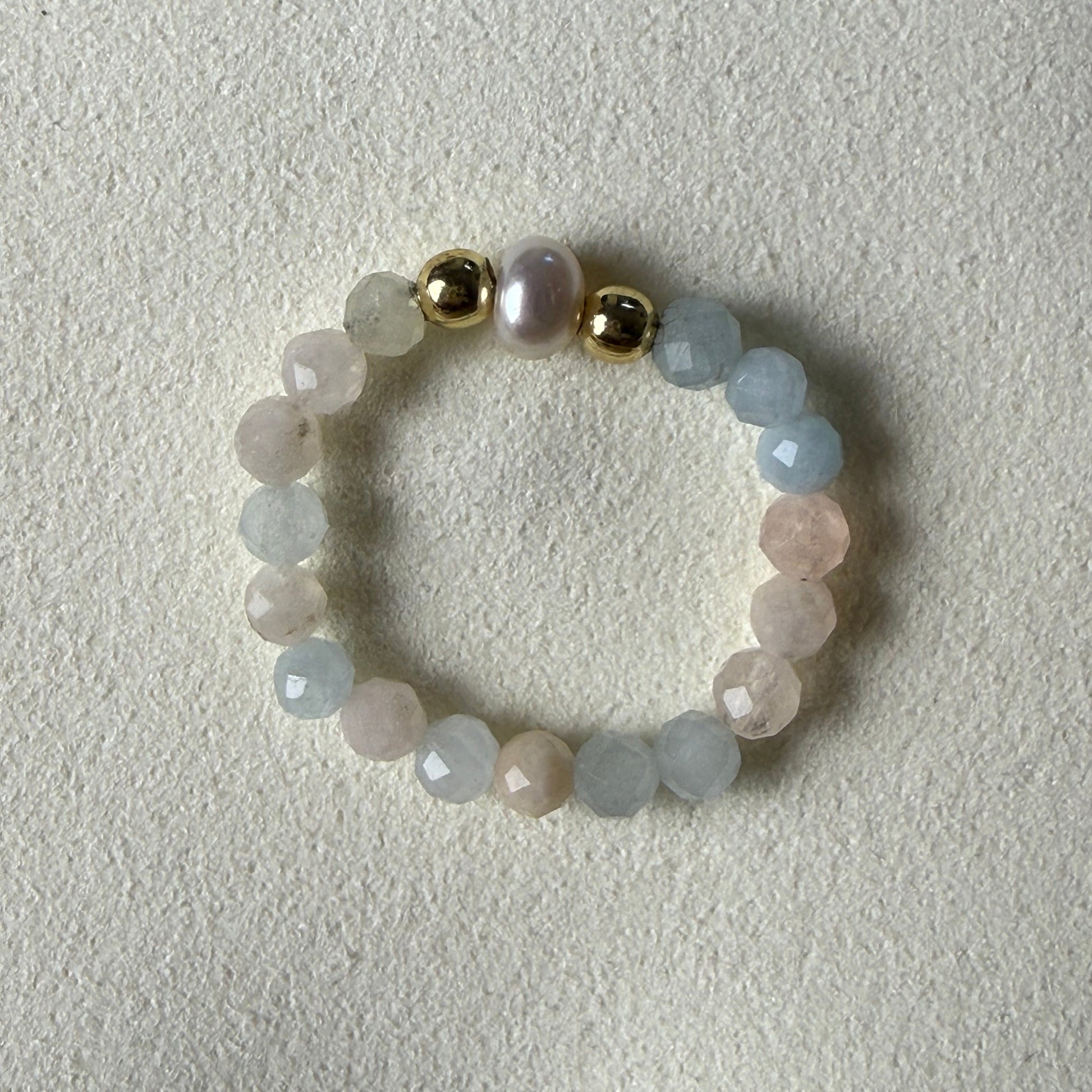 Close-up of pastel pink, peach and lilac faceted morganite beads with freshwater pearl and gold accents – Manushaa Gems
