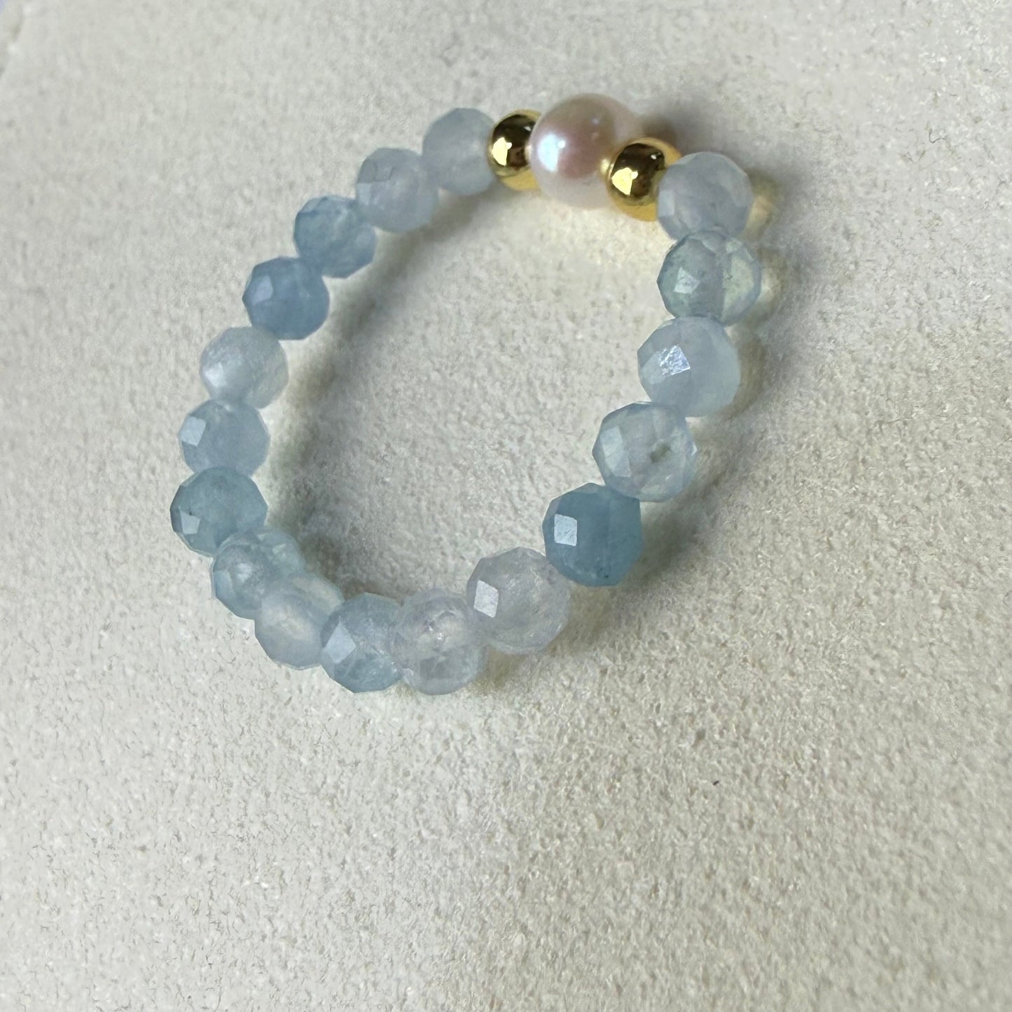 Macro detail of faceted aquamarine beads and unique freshwater pearl – handmade stretch ring by Manushaa Gems