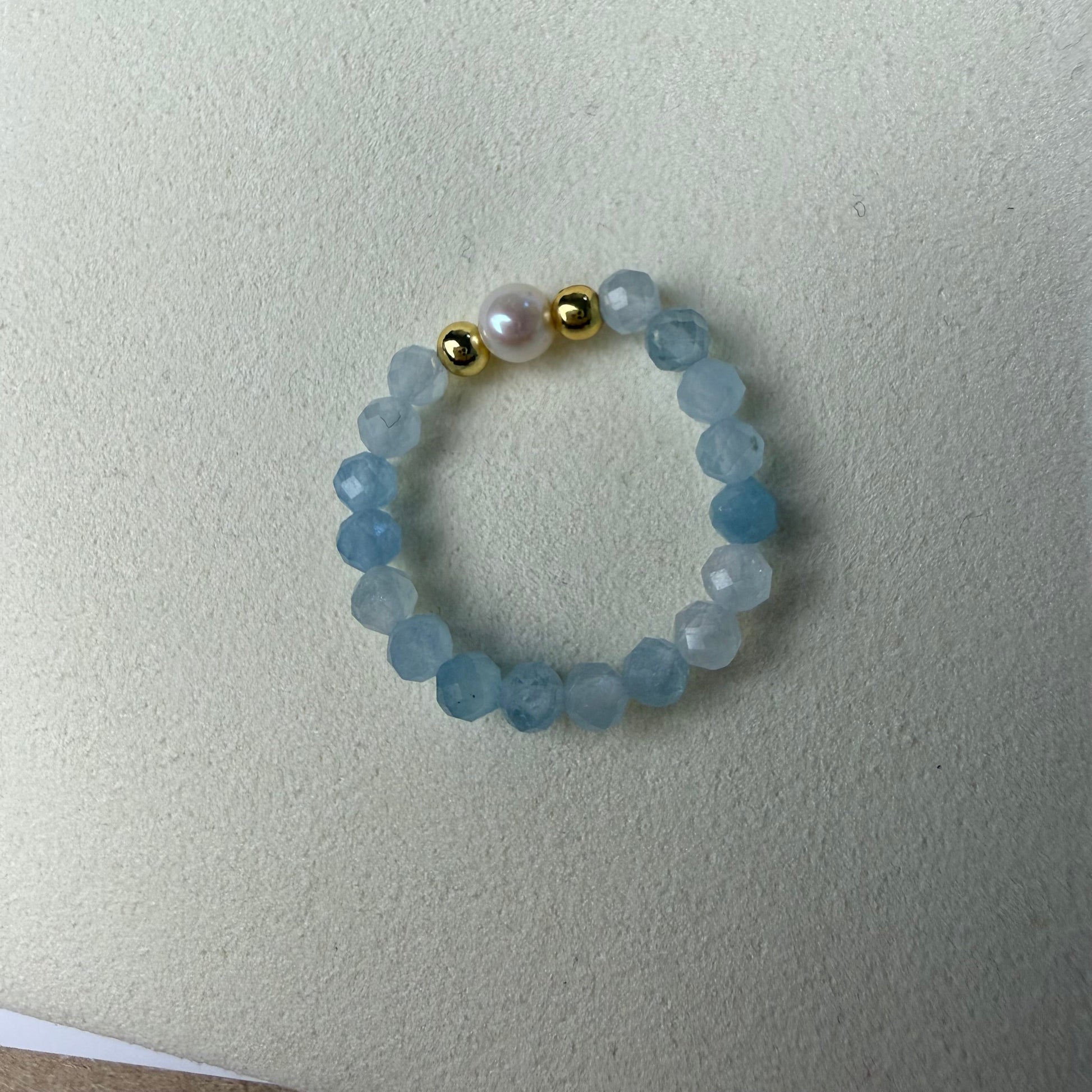 Close-up of pale blue faceted aquamarine beads with freshwater pearl and gold accents – Manushaa Gems