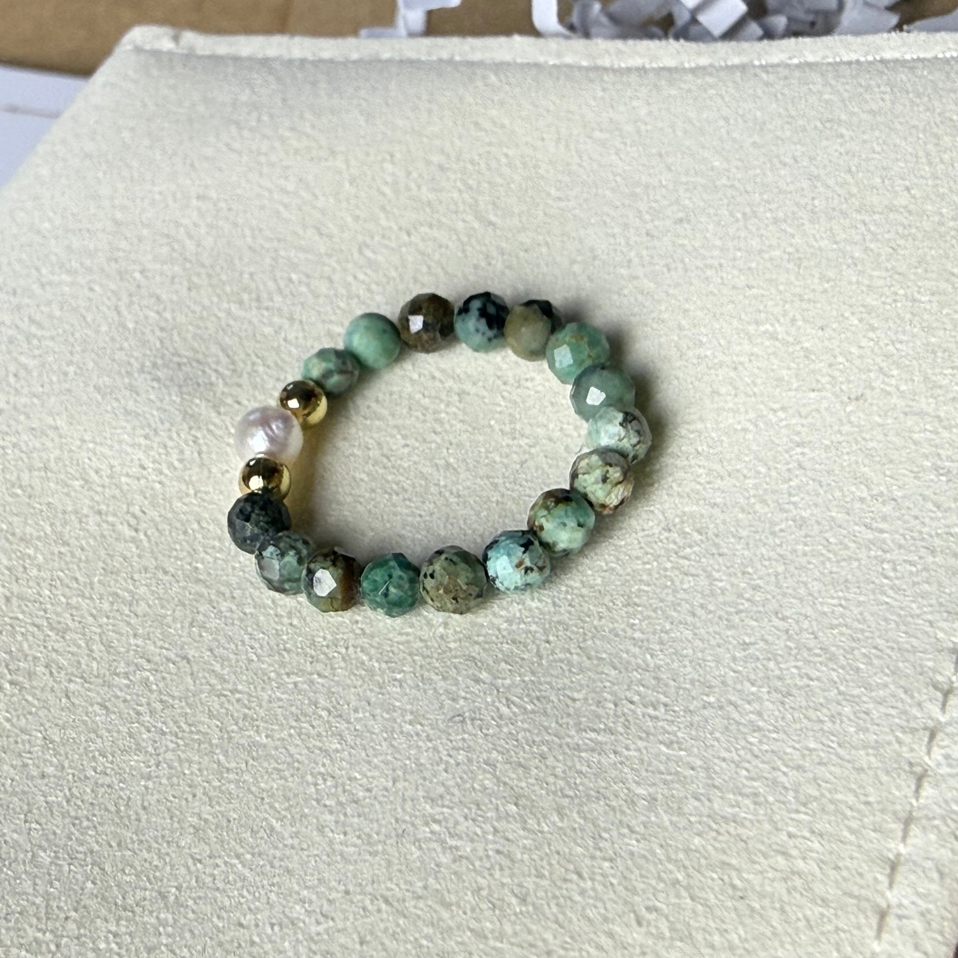 Close-up of teal green speckled African turquoise beads with freshwater pearl and gold accents – Manushaa Gems