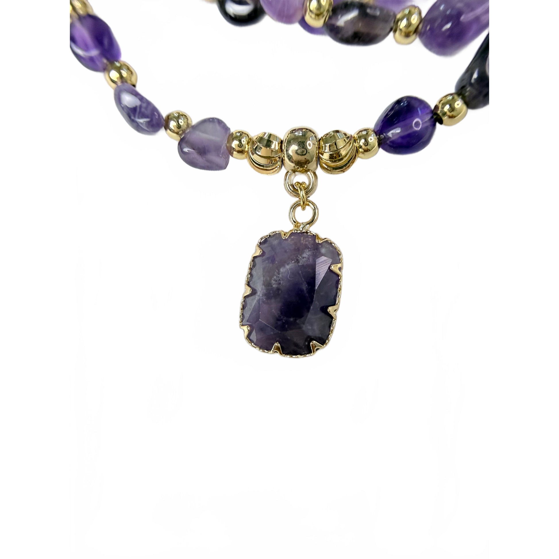 Detail of tumbled natural amethyst nugget beads in lilac and deep violet with gold accent beads