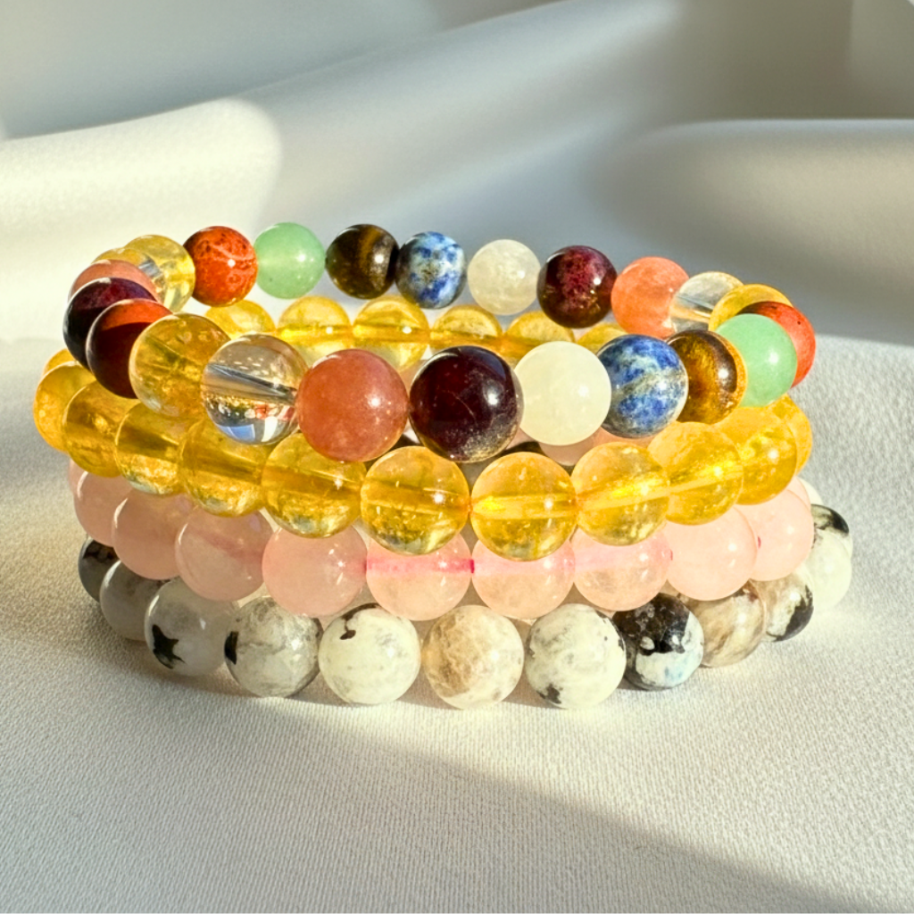 various crystal bracelets with 8mm polished beads on a white background