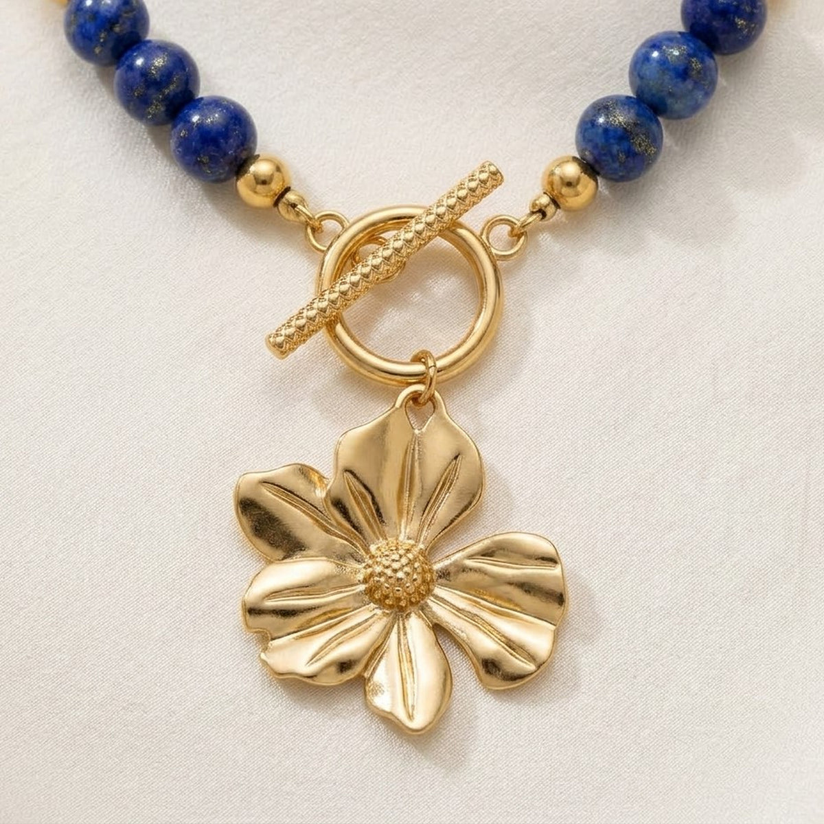 Gold-tone flower pendant and front toggle clasp close-up