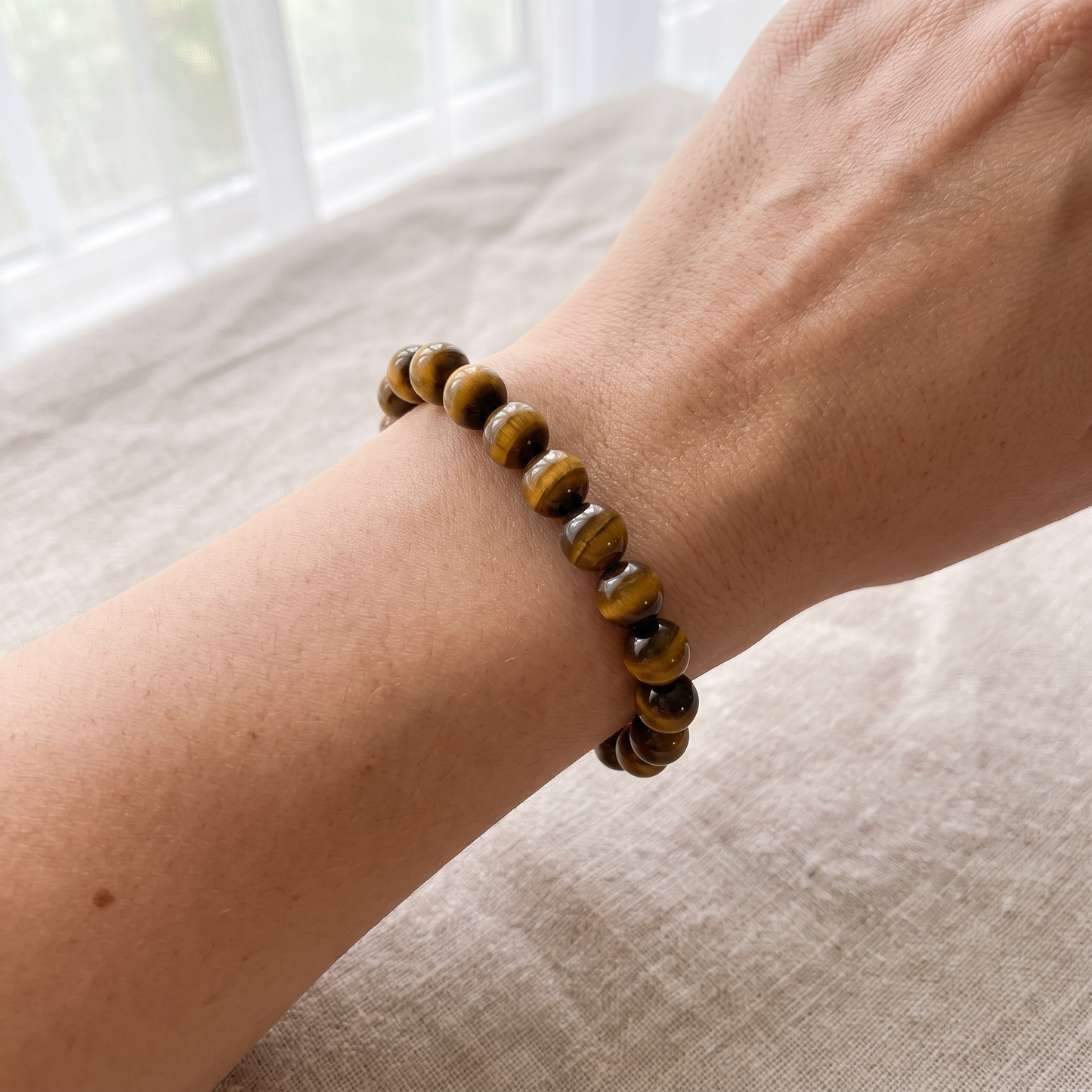 Tiger's Eye 8mm bead size reference shown on wrist - Manushaa Gems