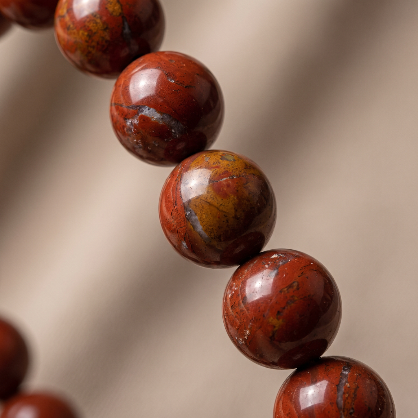 Macro close-up of deep brick-red Red Jasper 10mm crystal beads showing earthy texture