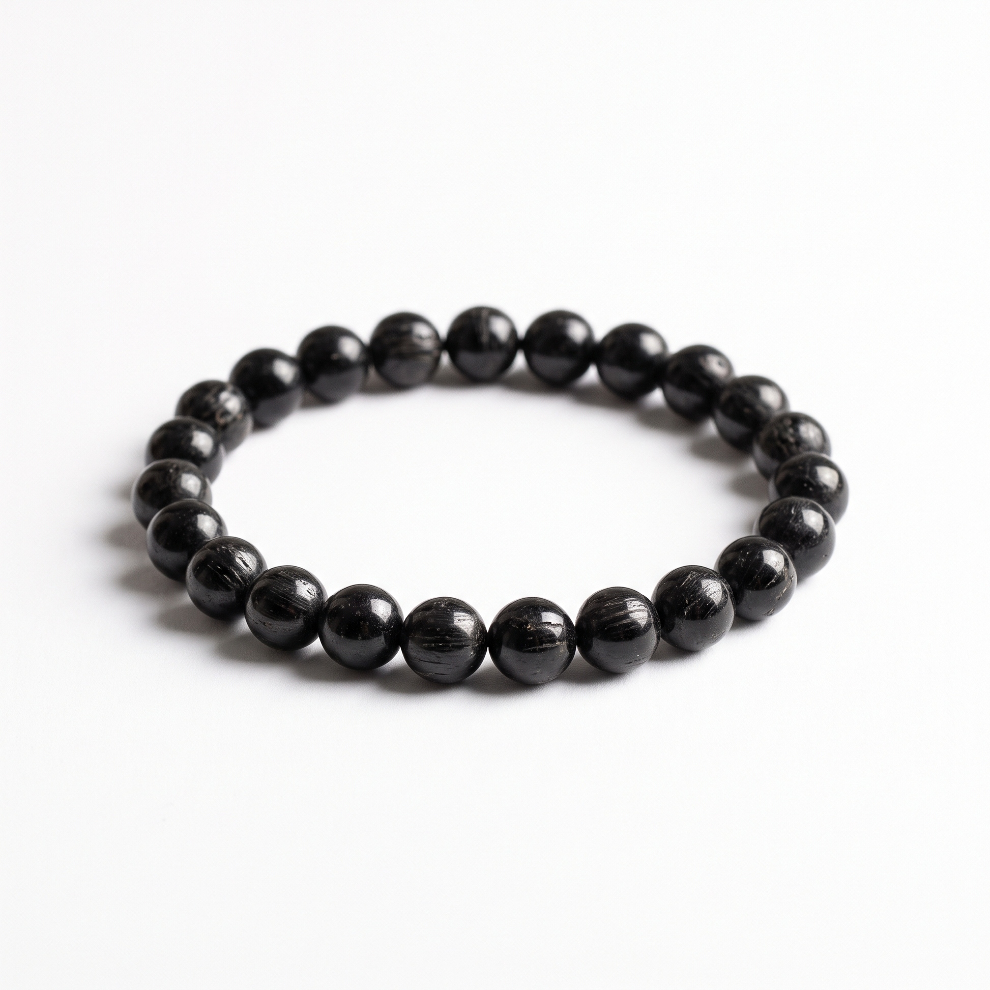 Natural Black Tourmaline 8mm crystal beaded stretch bracelet on white background - Manushaa Gems