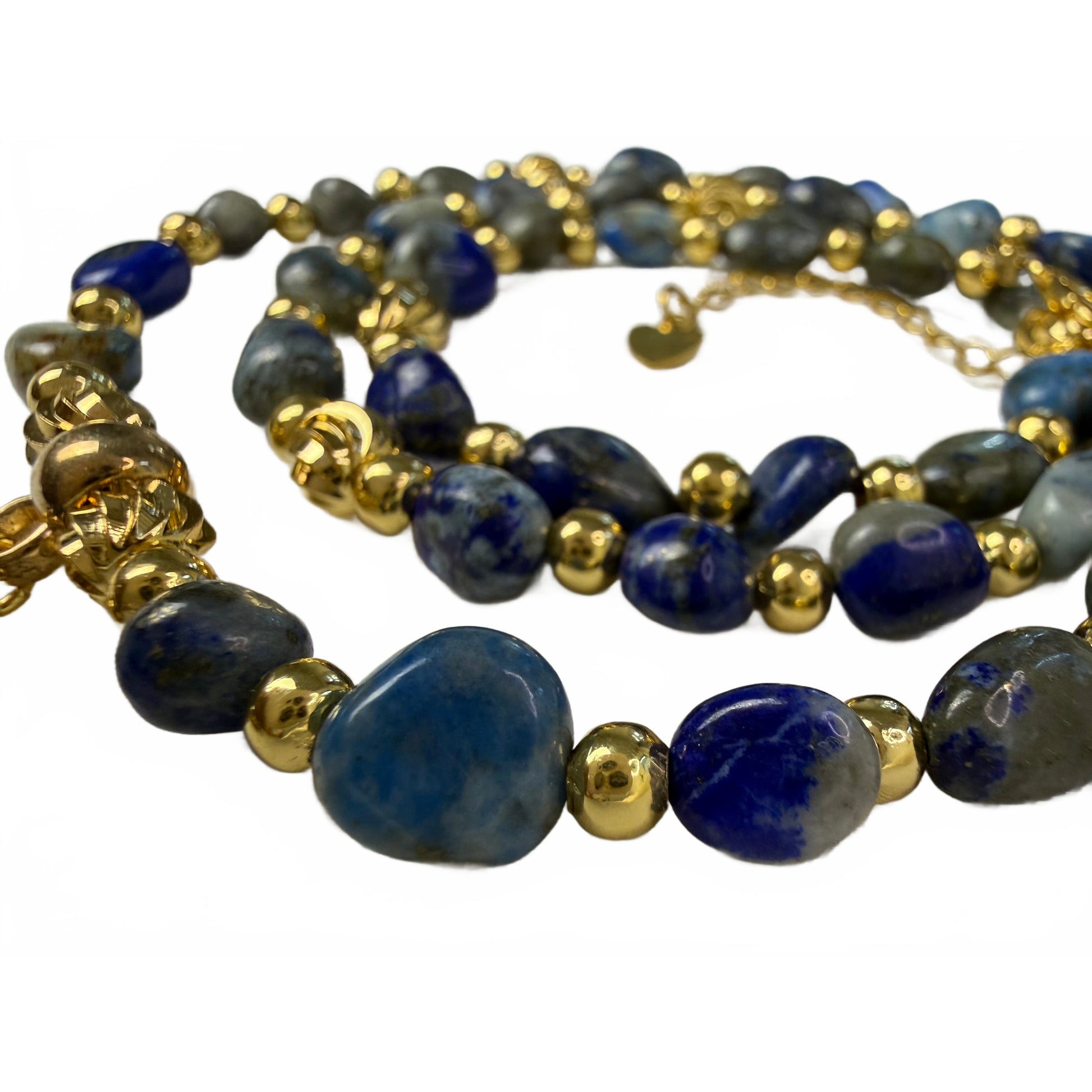 Detail of tumbled natural lapis lazuli nugget beads in deep blue and grey-blue with gold accent beads