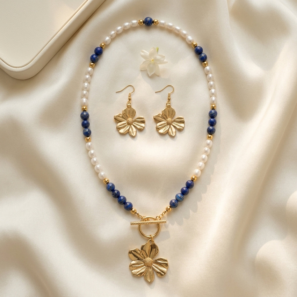 Lapis Lazuli and freshwater pearl jewellery set displayed on ivory fabric
