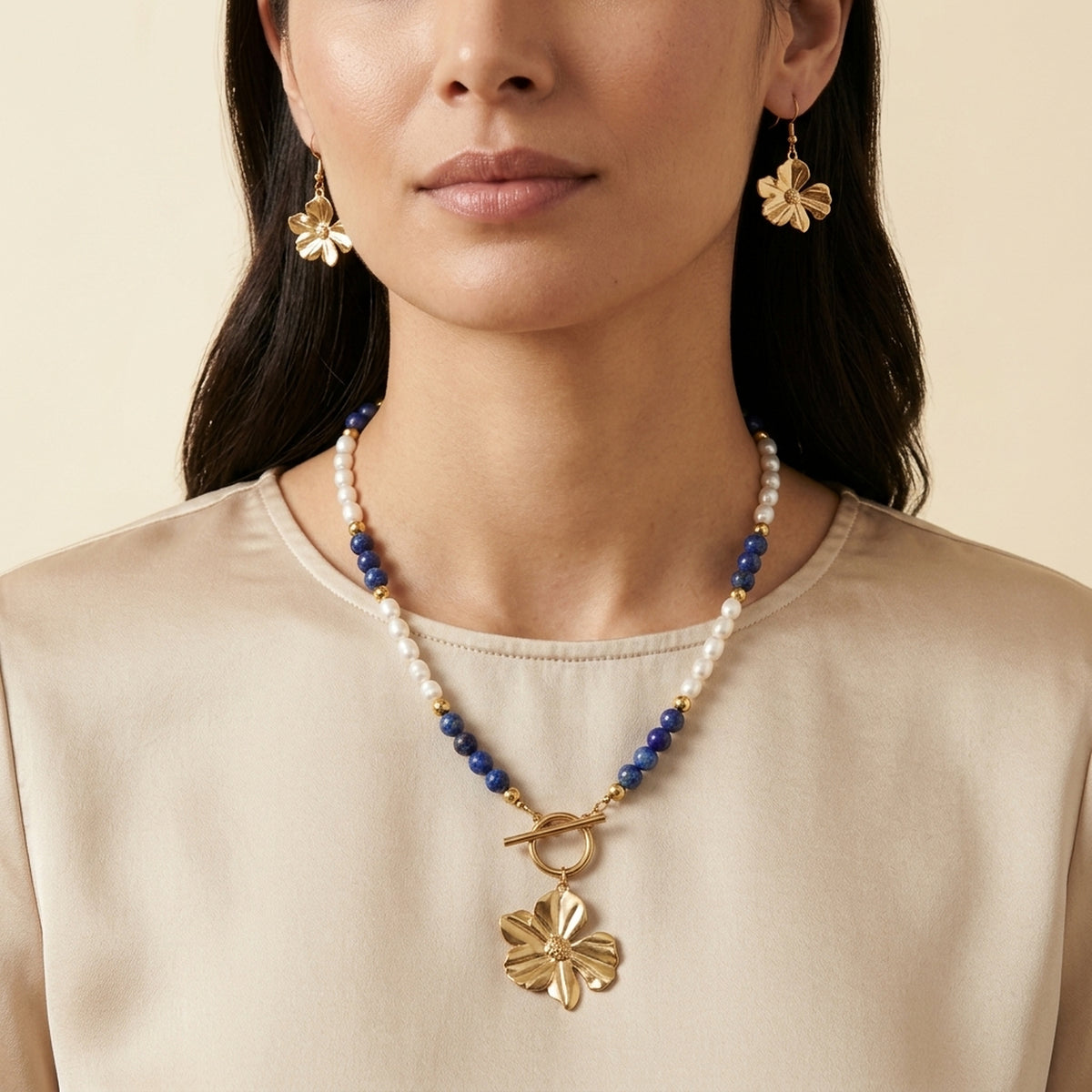 Woman wearing Lapis Lazuli and freshwater pearl necklace with matching flower earrings