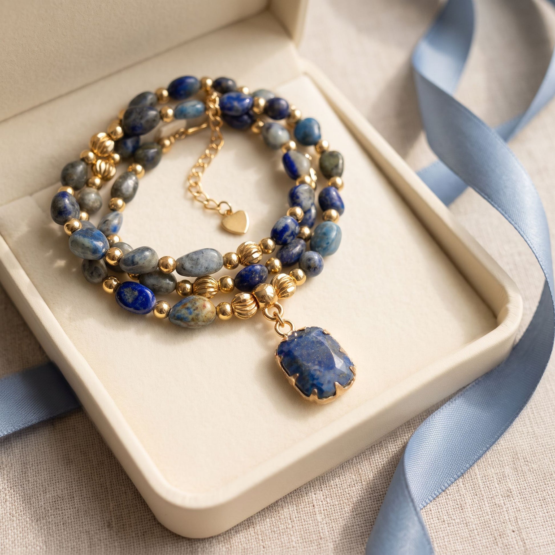 Lapis lazuli healing crystal necklace presented in a cream gift box with a dusty blue ribbon