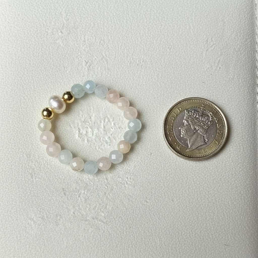 Multicolour morganite and freshwater pearl stretch ring beside a one pound coin for scale – Manushaa Gems