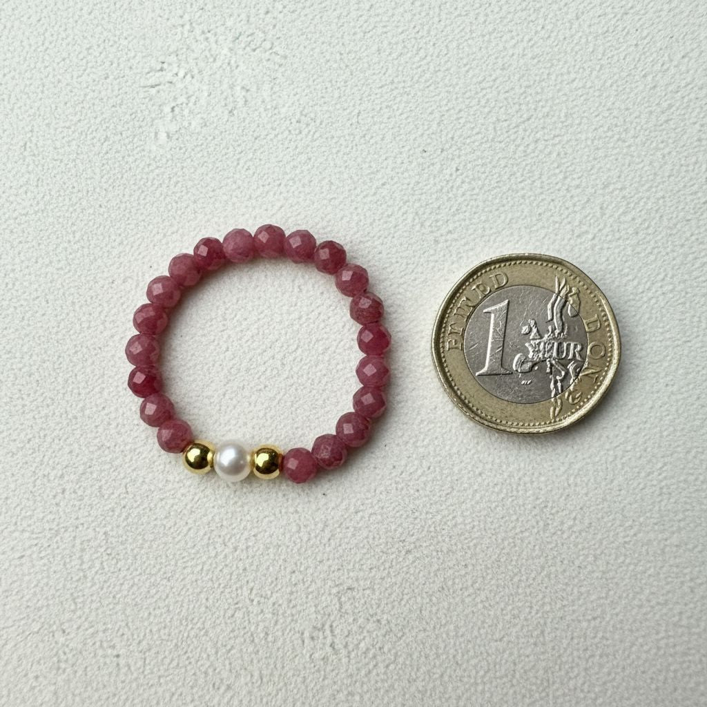 Rhodonite and freshwater pearl stretch ring beside a one pound coin for scale – Manushaa Gems