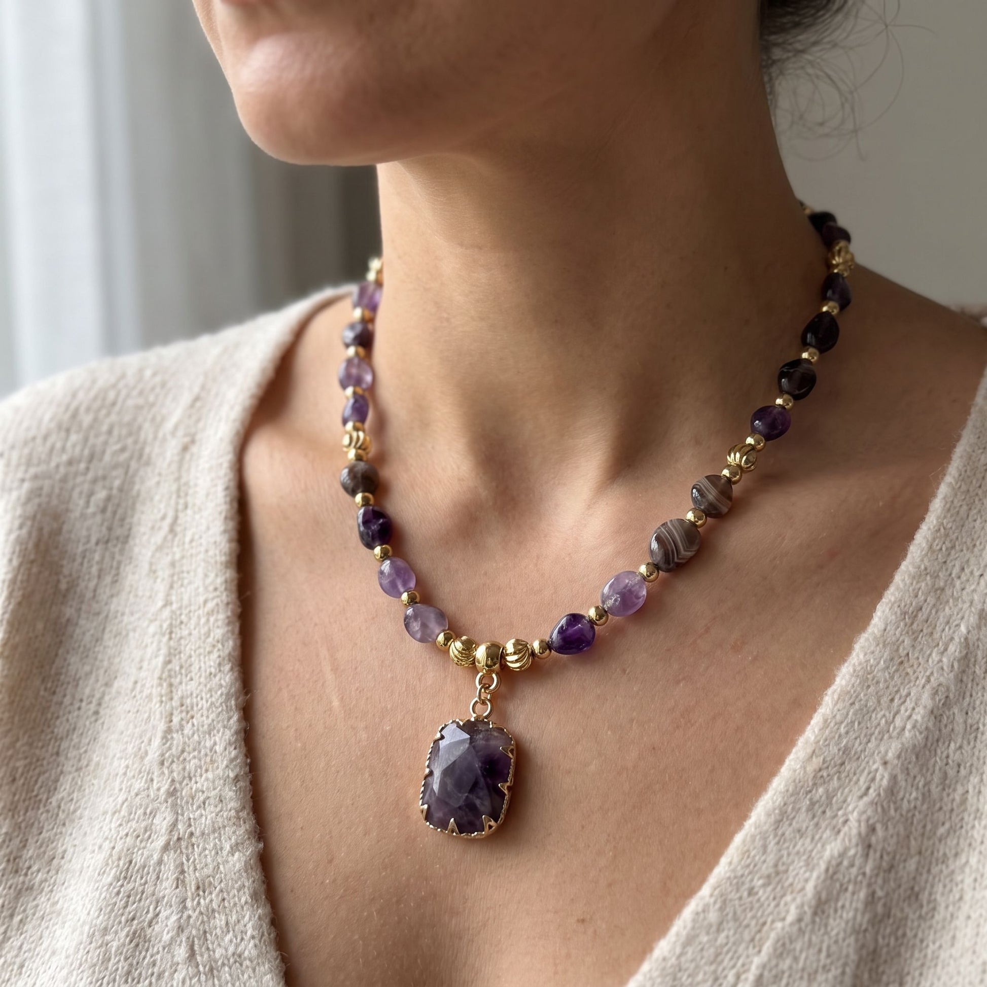 Woman wearing the natural amethyst healing crystal necklace, 45cm length with gold pendant