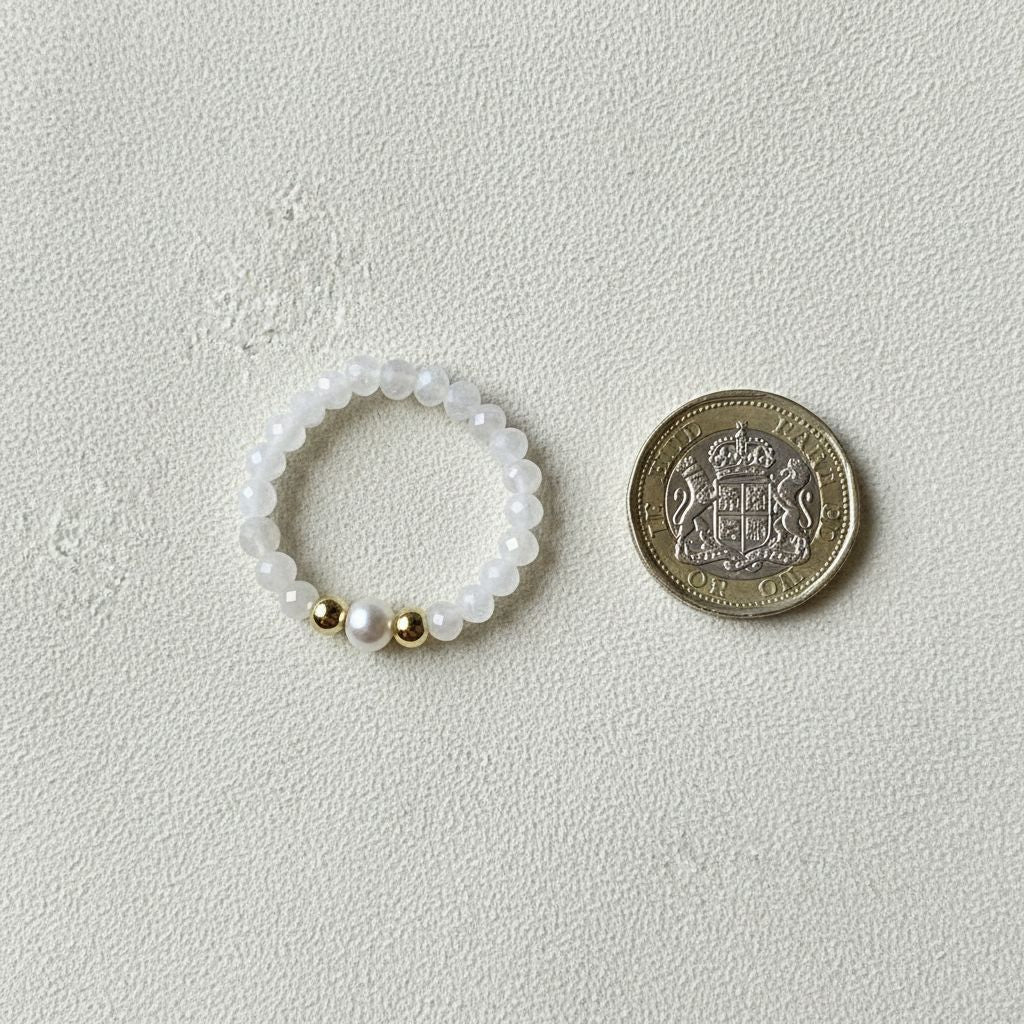 Moonstone and freshwater pearl stretch ring beside a one pound coin for scale – Manushaa Gems