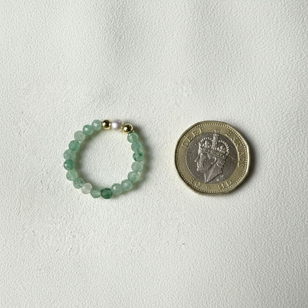 Green aventurine and freshwater pearl stretch ring beside a one pound coin for scale – Manushaa Gems